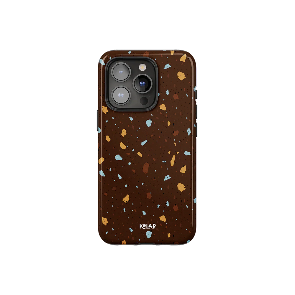 Brown marble terrazzo phone case by KELAB featuring a deep cocoa base with ochre, blue, and tan speckles. Stylish protection for iPhone models.
