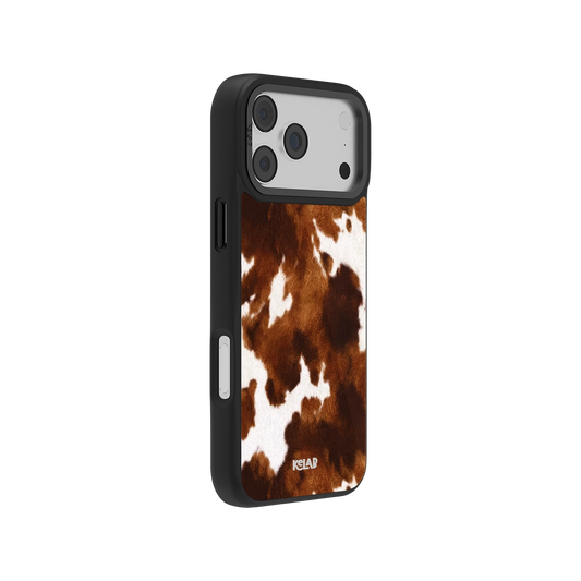 Side view of KELAB brown and white cowhide iPhone case featuring a classic country design with durable black bumper edges for added grip.